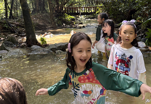Children exploring water and nature during a forest session